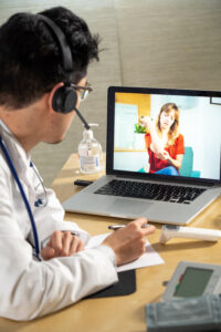 Doctor in remote consultation with 30 year old female patient with elbow pain